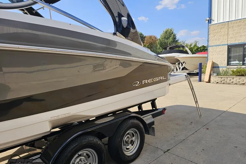 Slide: The Image of 2018 Regal 2500 Bowrider boat on trailer, parked outdoors near a building. - 24