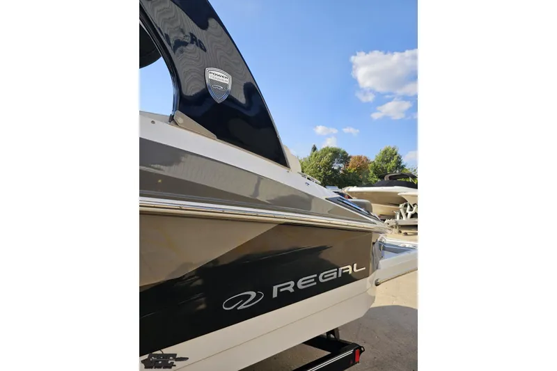 Slide: The Image of 2018 Regal 2500 Bowrider boat, sleek design, parked outdoors under blue sky. - 25