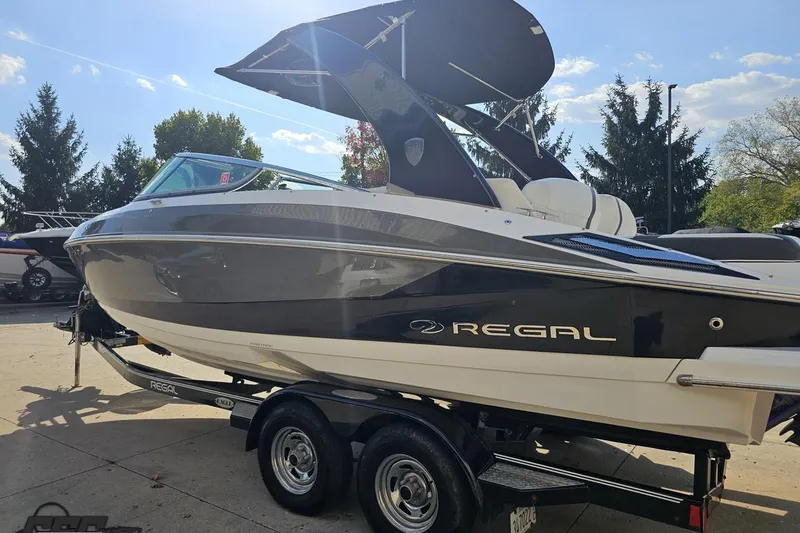 Slide: The Image of 2018 Regal 2500 Bowrider boat on trailer, sleek design, sunny day background. - 27