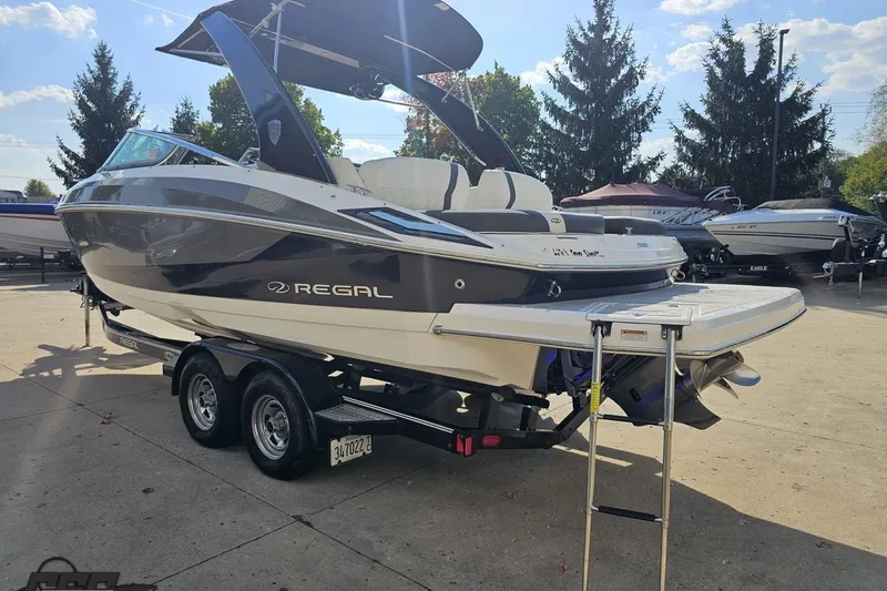 Slide: The Image of 2018 Regal 2500 Bowrider boat on trailer, parked outdoors under clear sky. - 28
