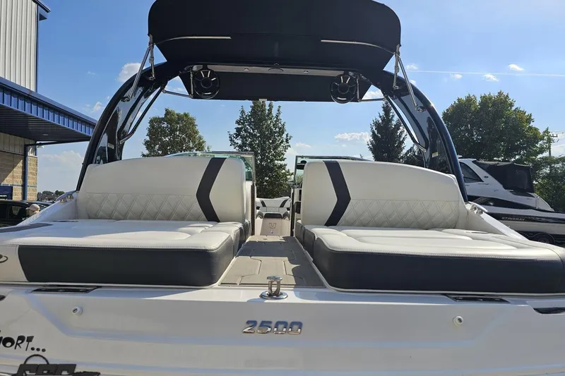 Slide: The Image of 2018 Regal 2500 Bowrider boat with sleek seating and canopy, parked outdoors. - 31