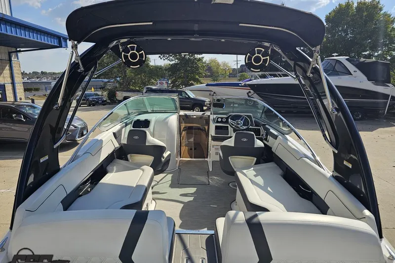 Slide: The Image of 2018 Regal 2500 Bowrider boat interior with seating and steering wheel, parked outdoors. - 36
