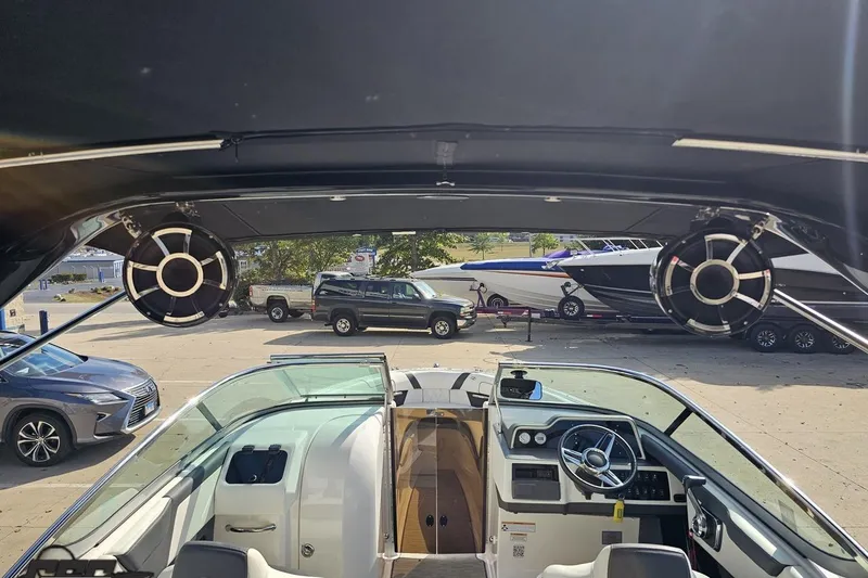 Slide: The Image of 2018 Regal 2500 Bowrider interior with speakers, steering wheel, and docked boats in background. - 47