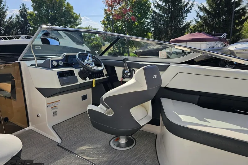 Slide: The Image of 2018 Regal 2500 Bowrider interior with steering wheel and seating, surrounded by trees. - 55