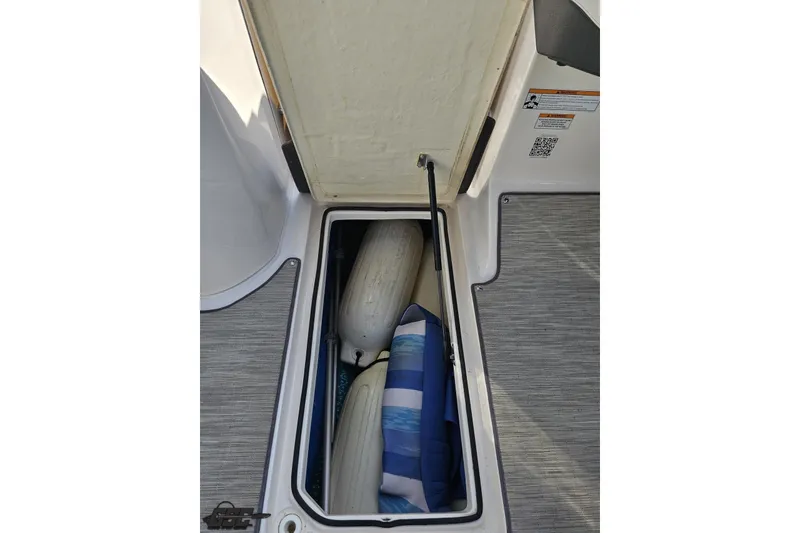 Slide: The Image of Open storage compartment in 2018 Regal 2500 Bowrider with fenders and cushion. - 60