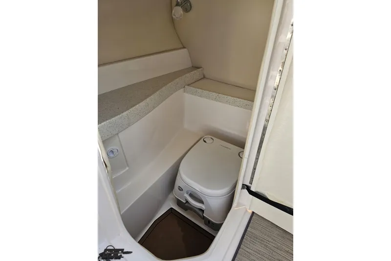 Slide: The Image of 2018 Regal 2500 Bowrider boat interior with compact toilet and countertop. - 64