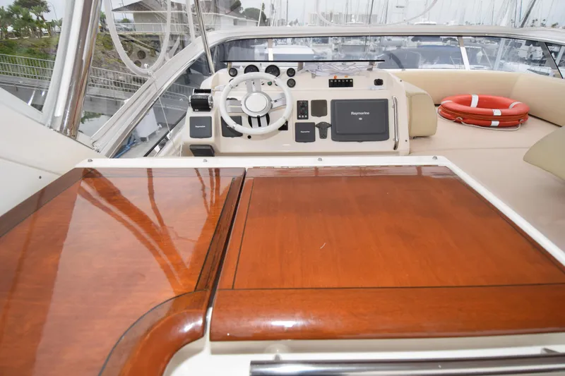 Slide: The Image of Cockpit of 2010 Azimut 58 yacht with polished wood table and navigation controls. - 25