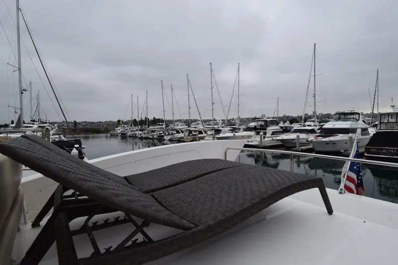 Slide: The Image of Luxurious 2010 Azimut 58 yacht with sun lounger, docked in a marina under cloudy skies. - 27