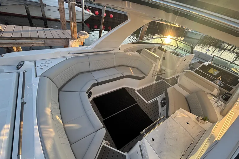 Slide: The Image of 2022 Searay SLX350 boat interior with luxurious seating and sunset view at the dock. - 10