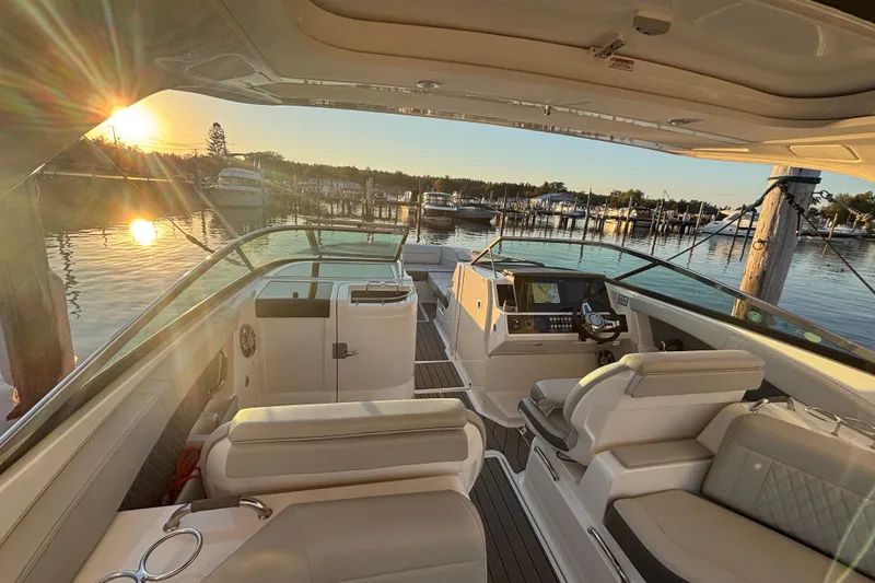 Slide: The Image of 2022 Searay SLX350 boat interior at sunset, docked in a serene marina. - 11