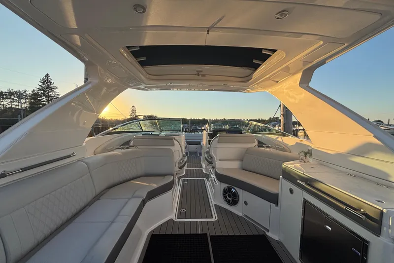 Slide: The Image of 2022 Searay SLX350 boat interior with luxurious seating and sunset view. - 13