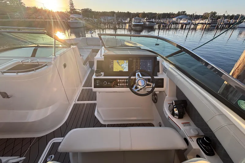 Slide: The Image of 2022 Searay SLX350 boat cockpit with modern controls, docked at sunset. - 15