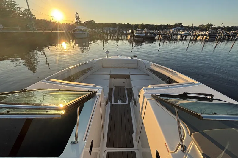 Slide: The Image of 2022 Searay SLX350 boat at sunset in a serene marina setting. - 17