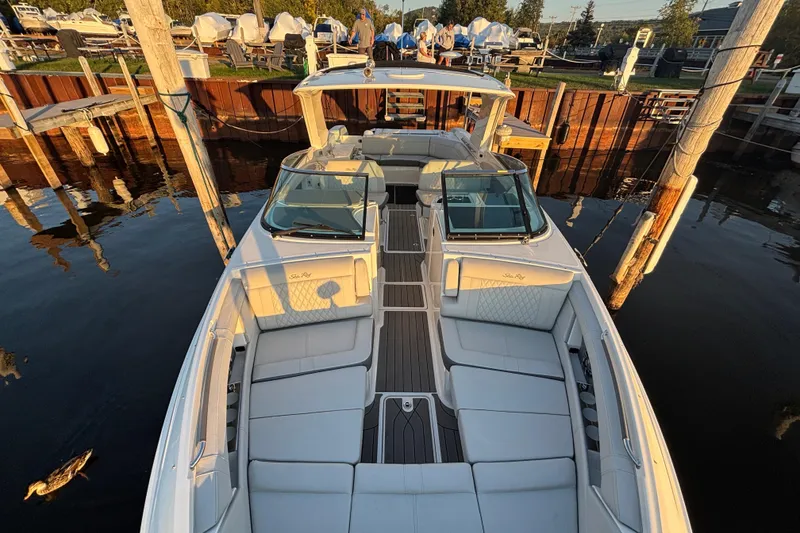 Slide: The Image of 2022 Searay SLX350 boat docked, featuring spacious seating and elegant design. - 19