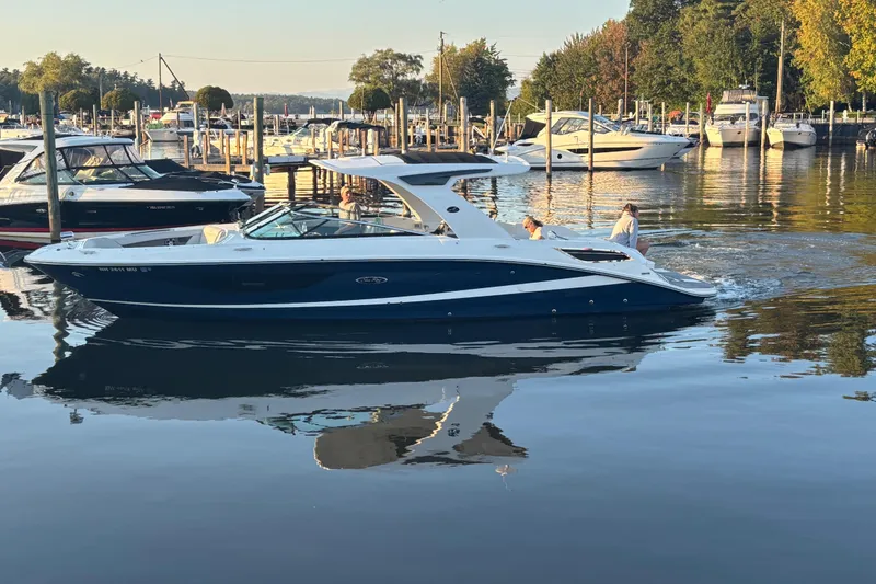 Slide: The Image of 2022 Searay SLX350 boat cruising in a serene marina setting. - 3