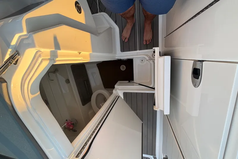 Slide: The Image of 2022 Searay SLX350 boat interior with open hatch and visible toilet. - 30