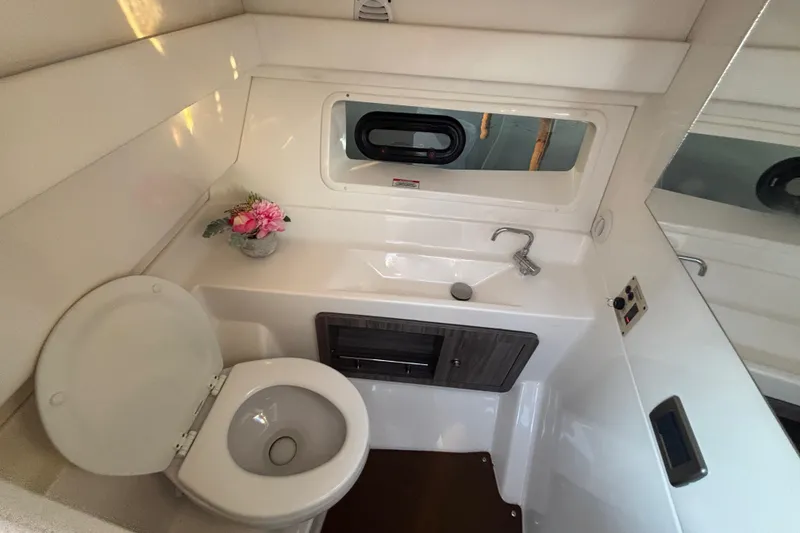 Slide: The Image of 2022 Searay SLX350 boat bathroom with toilet, sink, and window. - 31