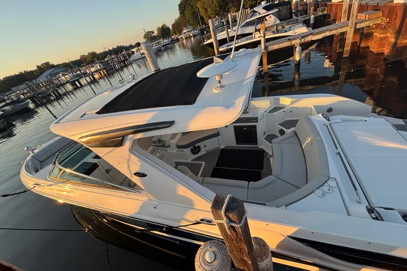 Slide: The Image of 2022 Searay SLX350 boat docked at marina during sunset, showcasing luxurious seating and sleek design. - 34