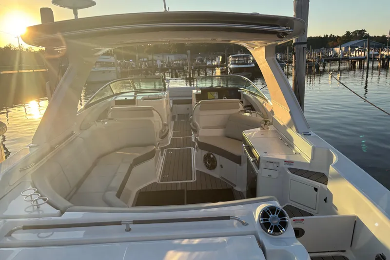 Slide: The Image of 2022 Searay SLX350 boat interior at sunset, docked in a serene marina. - 7