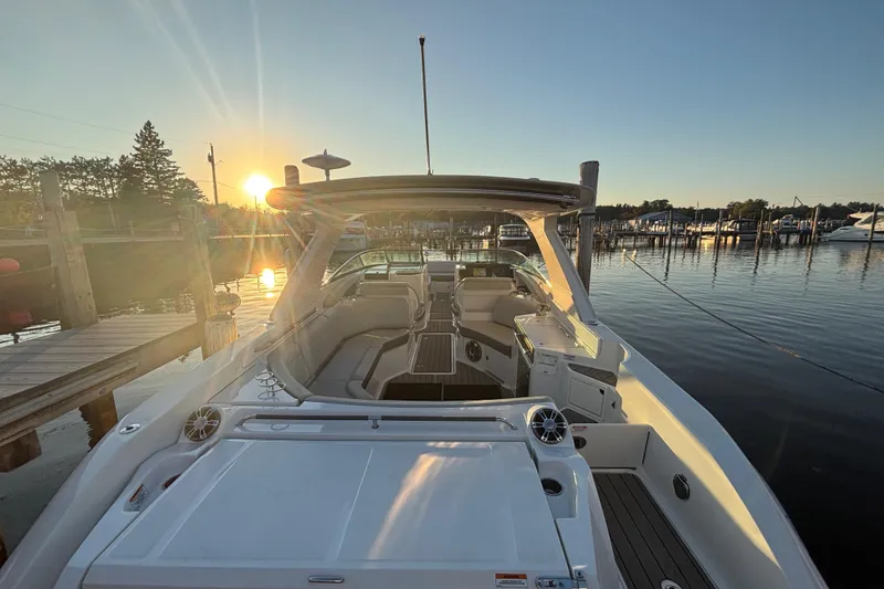 Slide: The Image of 2022 Searay SLX350 boat docked at sunset, showcasing luxurious interior and serene waterfront. - 8