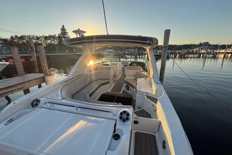Slide: The Image of 2022 Searay SLX350 boat docked at sunset, featuring spacious seating and modern design. - 9