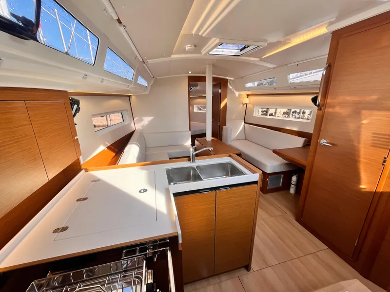 Slide: The Image of Interior of 2024 Jeanneau 380 yacht, featuring modern kitchen and seating area. - 13