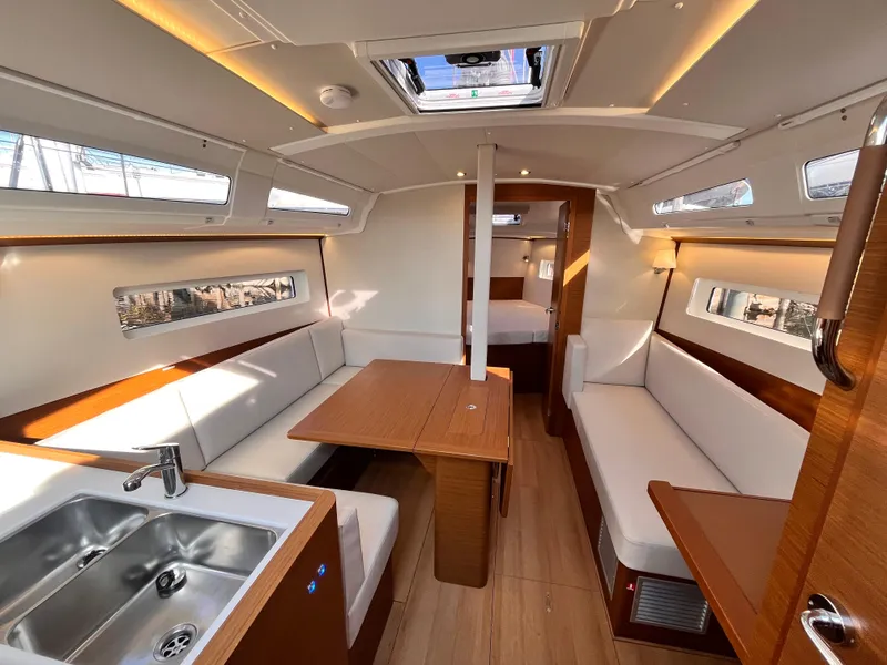 Slide: The Image of Interior of 2024 Jeanneau 380 sailboat, featuring modern seating, dining area, and kitchenette. - 14