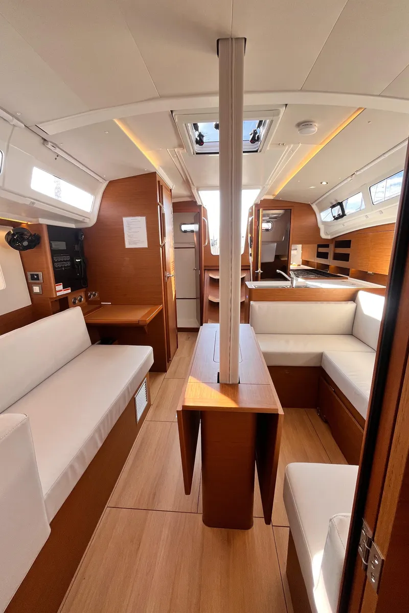Slide: The Image of 2024 Jeanneau 380 yacht interior with modern wood finish and white seating. - 19