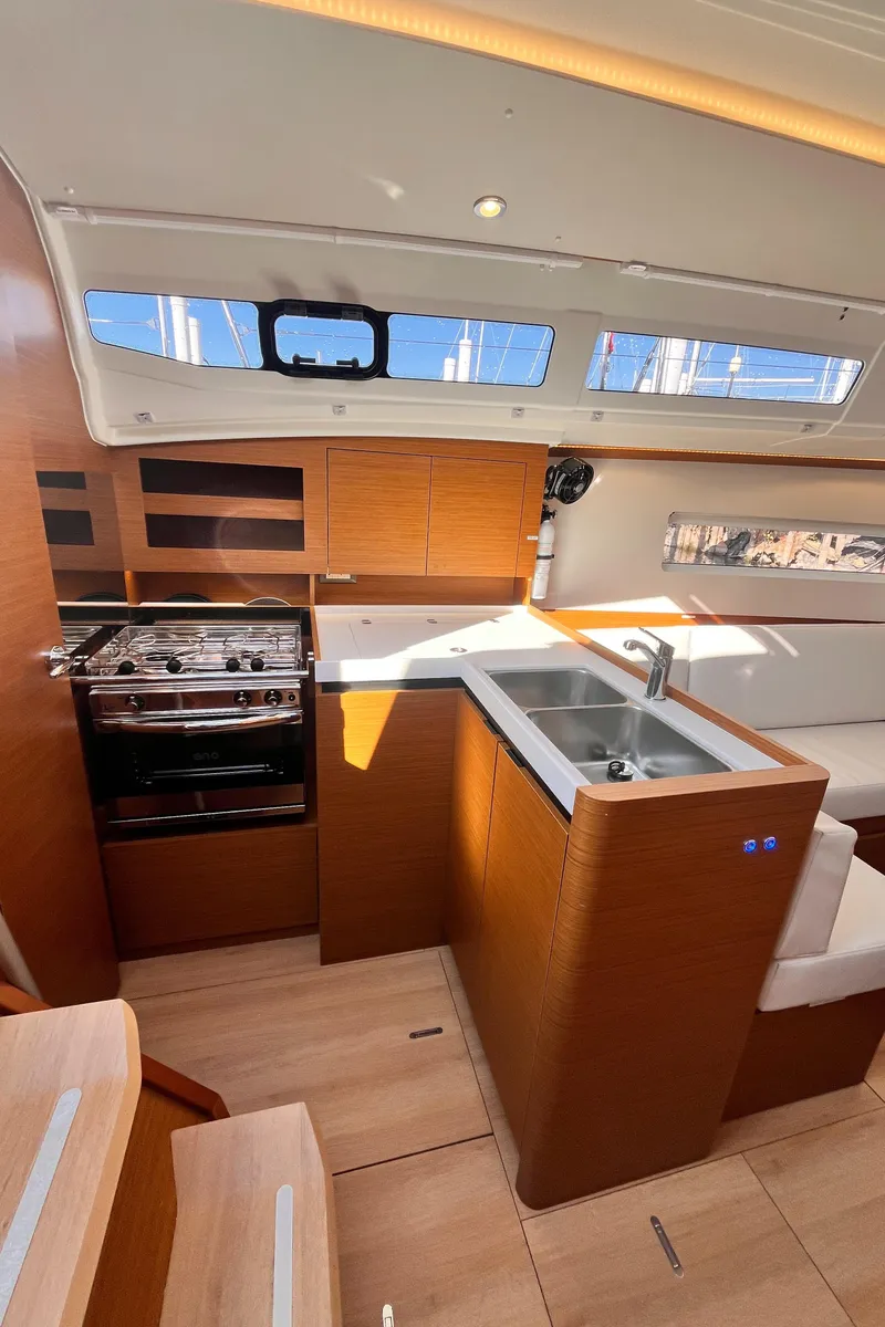 Slide: The Image of Modern kitchen interior of 2024 Jeanneau 380 yacht with wood finish and stainless steel appliances. - 24