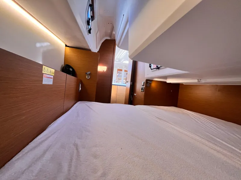 Slide: The Image of 2024 Jeanneau 380 interior cabin with wood paneling and cozy bedding. - 28