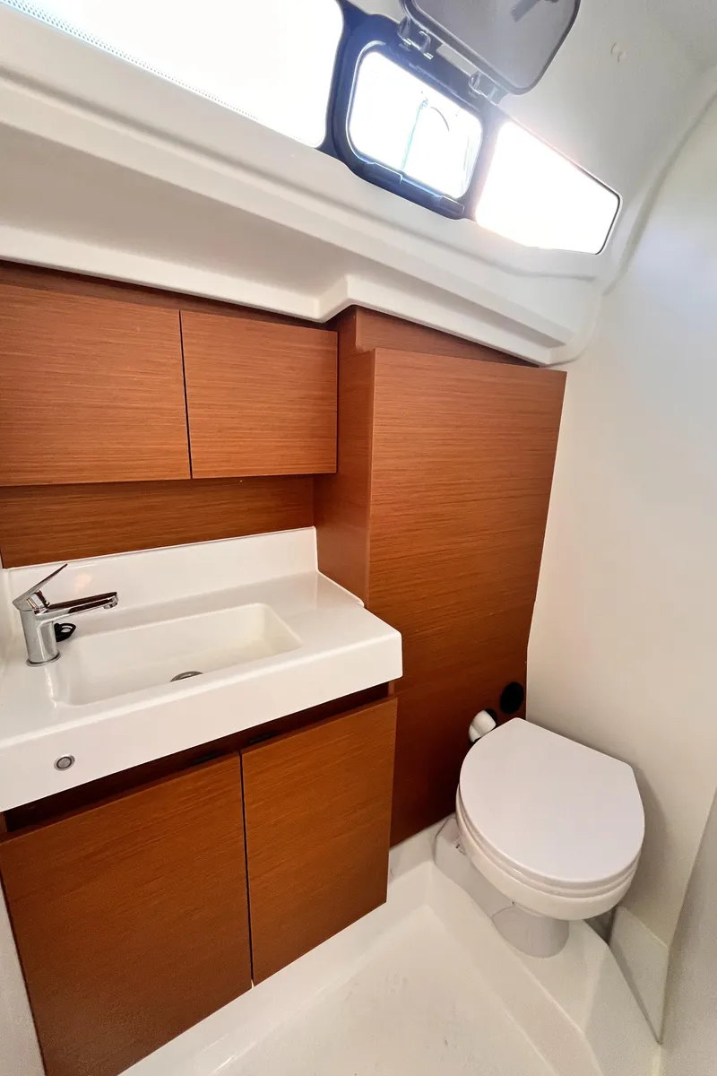 Slide: The Image of 2024 Jeanneau 380 yacht bathroom with modern sink, wooden cabinetry, and toilet. - 30
