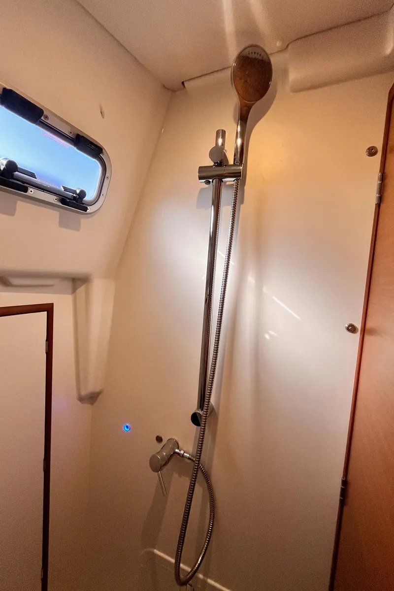 Slide: The Image of 2024 Jeanneau 380 yacht shower area with modern fixtures and porthole window. - 32