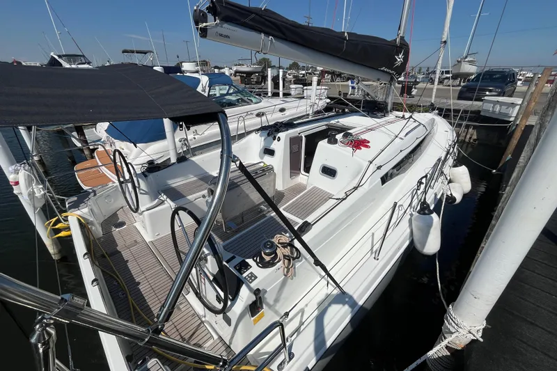 Slide: The Image of 2024 Jeanneau 380 sailboat docked at marina, featuring dual steering wheels and sleek design. - 9