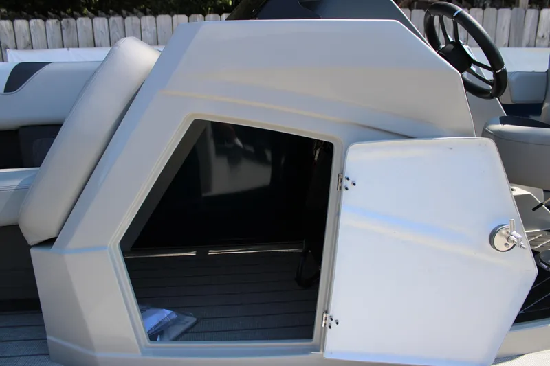 Slide: The Image of Starcraft SLS 3 Q DH 2026 boat storage compartment with open door and steering wheel. - 20