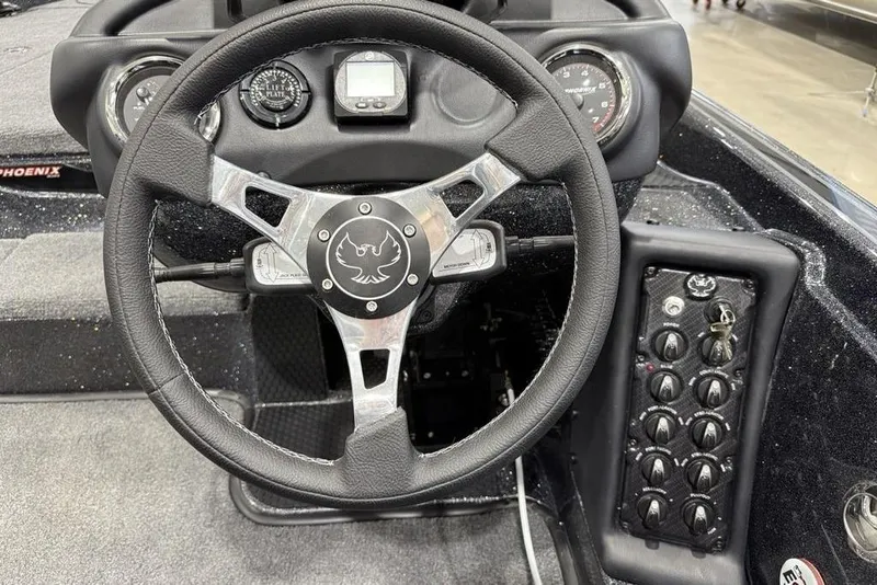 Slide: The Image of Steering wheel and dashboard of 2026 Phoenix 721 ZXL boat, featuring control panel and gauges. - 27