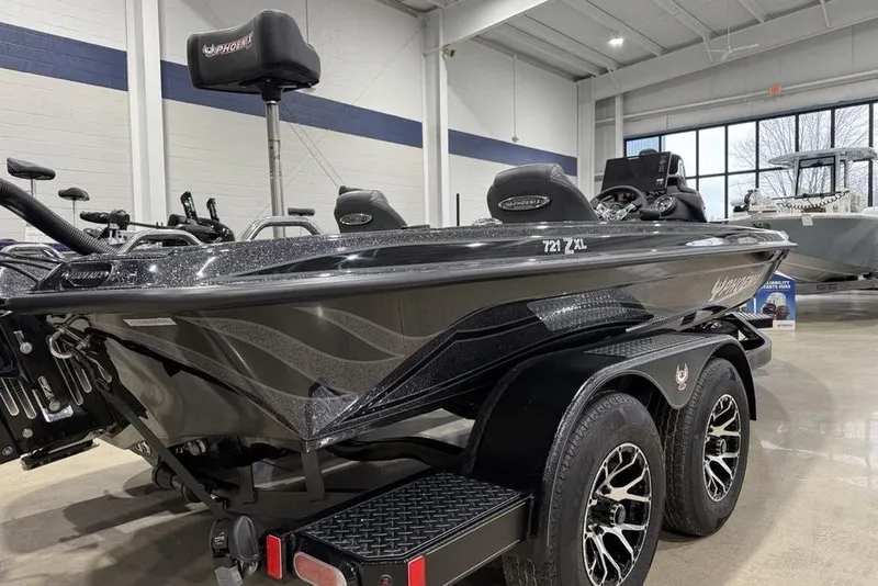 Slide: The Image of 2026 Phoenix 721 ZXL boat in showroom, sleek design, dual-axle trailer, modern interior. - 7