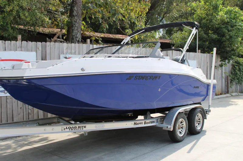 The Image of 2026 Starcraft SVX 190 OB boat on trailer, blue hull, parked outdoors. - 1