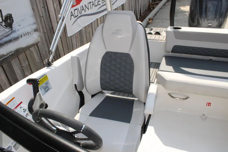 Slide: The Image of 2026 Starcraft SVX 190 OB boat interior with steering wheel and cushioned seating. - 10