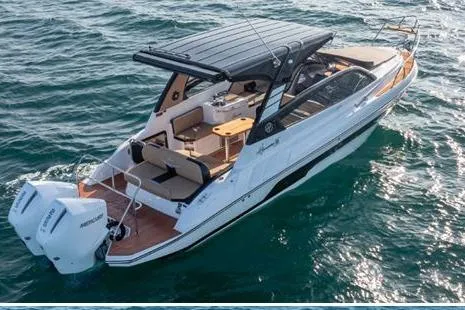 Slide: The Image of 2026 Hanover 305 White and Black Premium Edition boat cruising on open water. - 3