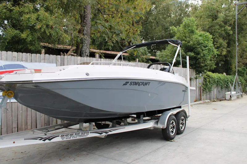 Slide: The Image of 2025 Starcraft SVX 211 OB boat on trailer, parked outdoors. - 1