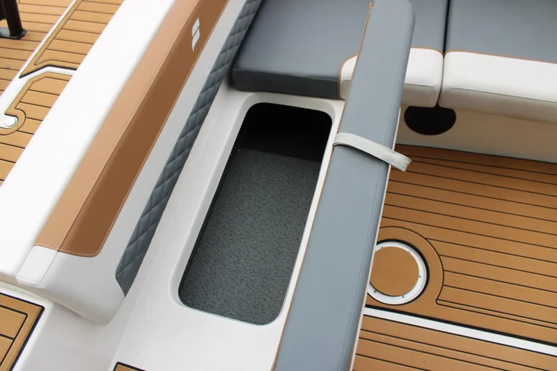 Slide: The Image of 2025 Starcraft SVX 211 OB boat interior with cushioned seating and storage compartment. - 11