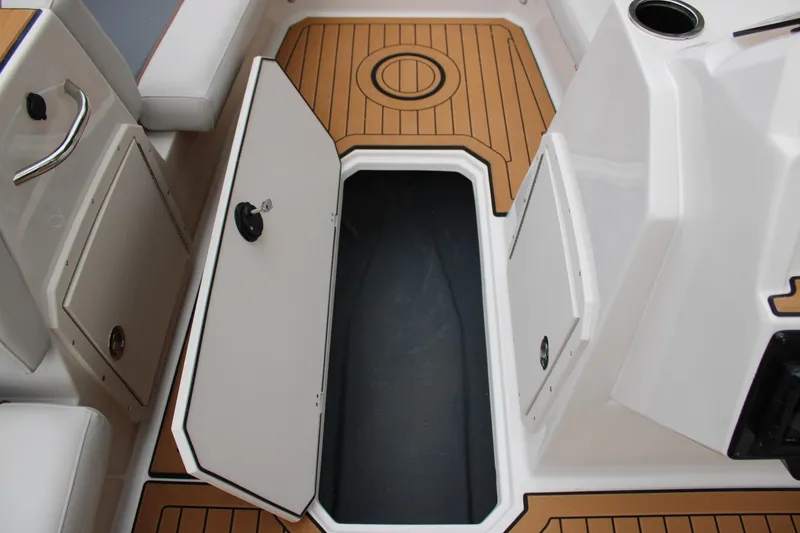 Slide: The Image of 2025 Starcraft SVX 211 OB boat interior with open storage compartment and teak flooring. - 14