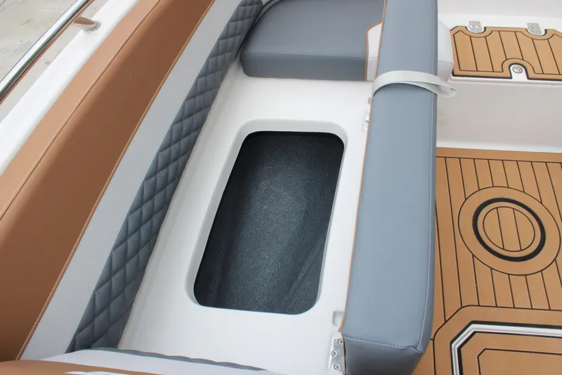Slide: The Image of 2025 Starcraft SVX 211 OB boat interior with cushioned seating and storage compartment. - 18