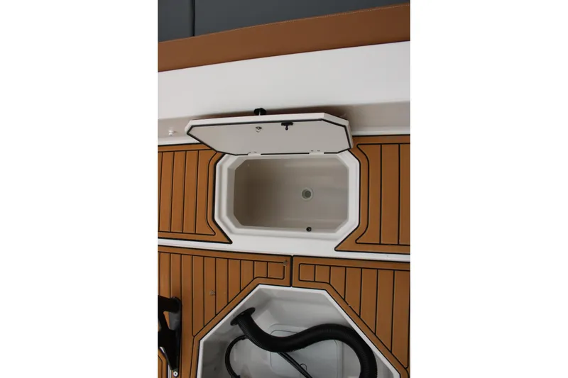 Slide: The Image of 2025 Starcraft SVX 211 OB boat interior with open storage compartment and wood-patterned flooring. - 7