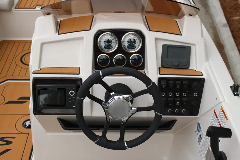Slide: The Image of 2025 Starcraft SVX 211 OB boat dashboard with steering wheel and control panel. - 8