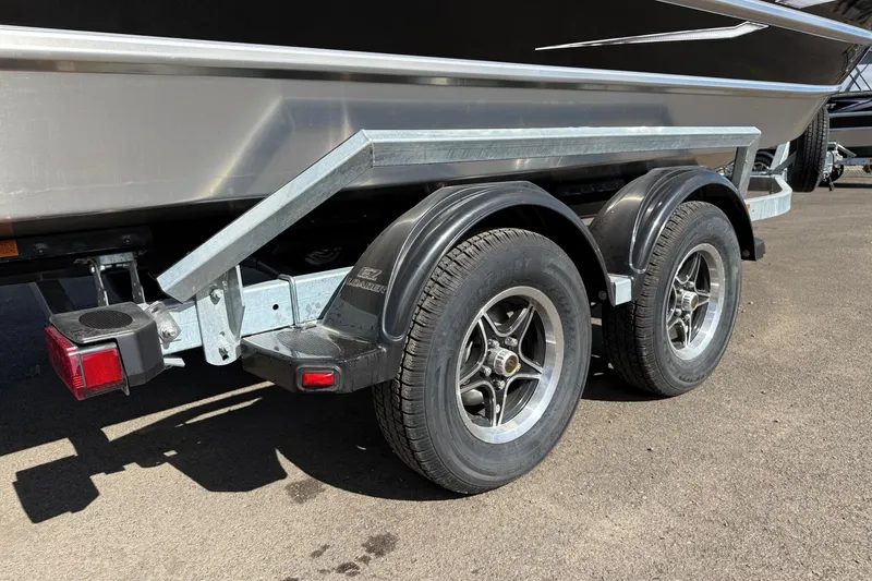 Slide: The Image of Trailer for 2025 Thunder Jet 200 Luxor boat with dual wheels on pavement. - 6