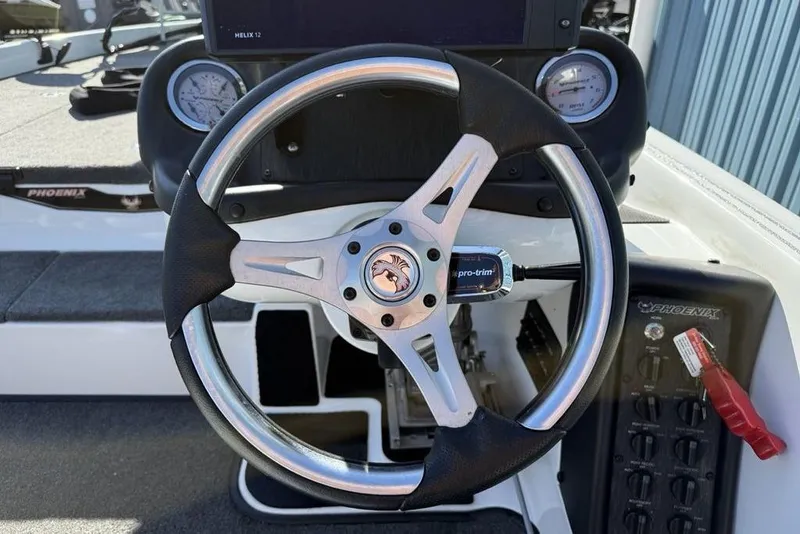 Slide: The Image of Steering wheel of 2019 Phoenix 618 Pro boat with dashboard controls and gauges. - 12