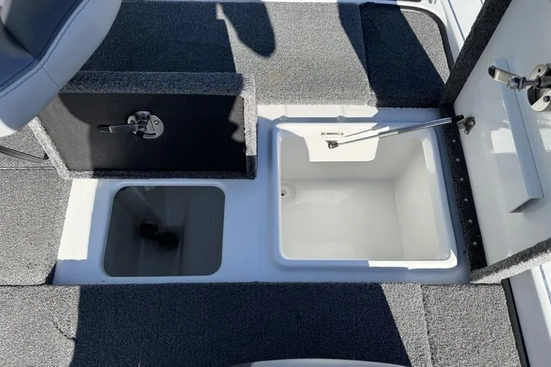 Slide: The Image of 2019 Phoenix 618 Pro boat storage compartments with open hatches and carpeted flooring. - 16