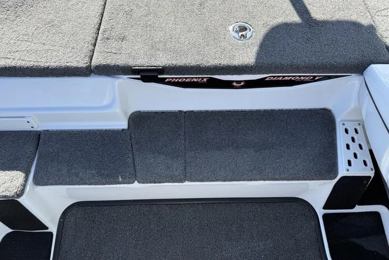 Slide: The Image of 2019 Phoenix 618 Pro boat interior with gray carpeted steps and storage compartment. - 18
