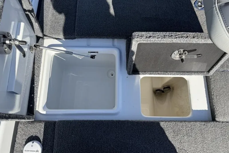 Slide: The Image of 2019 Phoenix 618 Pro boat storage compartments with open lids and carpeted interior. - 19
